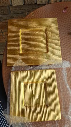 Two gold ribbed candle dishes