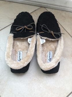 “Alpine Design” Two pair of black, faux-fur-lined moccasin-style slippers with decorative leather laces.