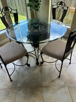 5PC GLASS & WROTH IRON DINETTE TABLE EXCELLENT CONDITION (ARMY GREEN) 4 CHAIRS  COMES WITH  GLASS TABLE PROTECTOR MINOR SPOTS IN TWO CHAIRS pick up at