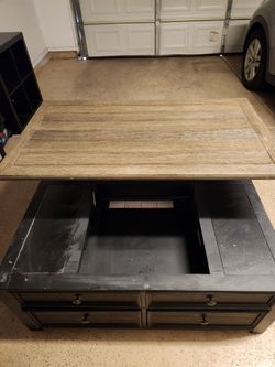 Large black coffee table with wood surface and drawers