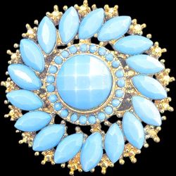 This is a vintage gold-tone flower brooch with light blue faceted plastic stones. 
