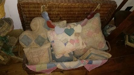 Basket trunk with several antique quilt piece pillows