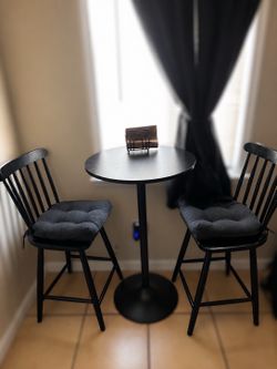 Black round pedestal table with 2 bar stools