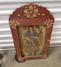 Folk art retablo painting of an angel, likely Archangel Raphael.  Retablos are devotional folk art paintings, traditionally created on tin or copper s