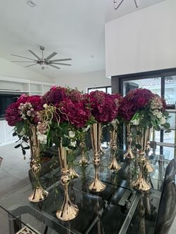 12 flower centerpieces with tall, metal trumpet vase