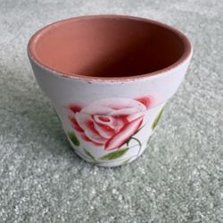 Handpainted terra-cotta plant pot featuring a white base with a pink flower and Bee