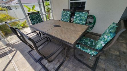 7-piece dining set in very good condition. 
Set includes six outdoor dining chairs and one tile-top dining table.

All-weather construction sealed wit