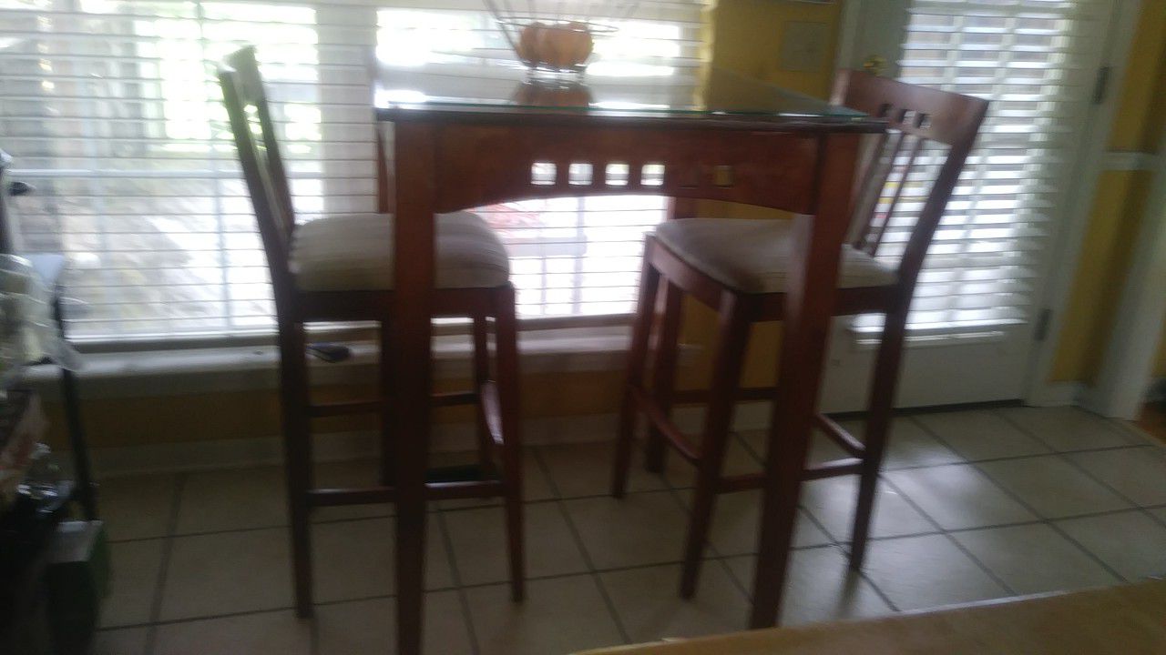 Tall Kitchen table 2 chairs solid wood. Table has glass on top.