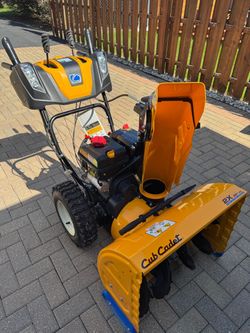 For sale: Cub Cadet 2X 26" snow blower. This yellow and black machine features a 26-inch clearing width and a two-stage power system.