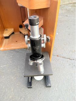 Vintage Bausch & Lomb U.S. Navy microscope with original wooden storage/carrying case and accessories.