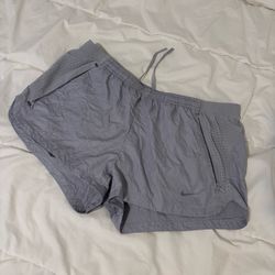 Women’s medium Nike gray running shorts with perforated side panels and inside mesh lining.