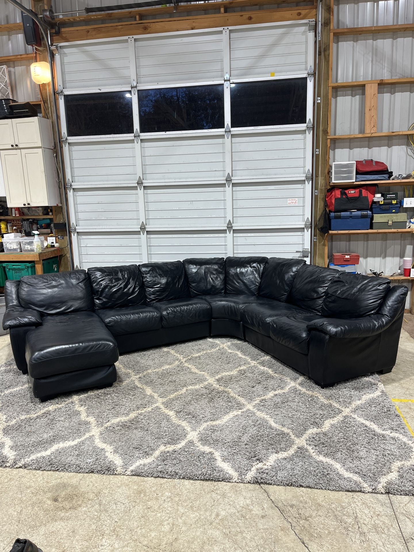 This is a large, comfortable black leather sectional with a left-side chaise. It’s super roomy, clean, and perfect for a living room, bonus room, or m