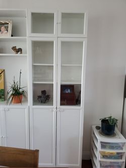 Two Ikea Billy bookcases with extenders and glass doors