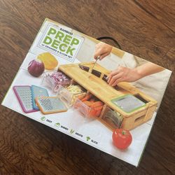 A durable cutting board with four drawers or two stainless steel trays, featuring a juice groove, easy-grip handles, and a sliding opening mechanism.