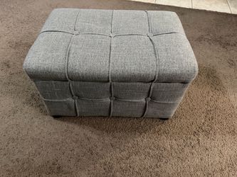 Small tufted storage ottoman with lift top hinged storage.
