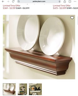 2 brown solid wood Pottery Barn floating shelves with crown molding detailing, & a plate/frame/disc ledge.