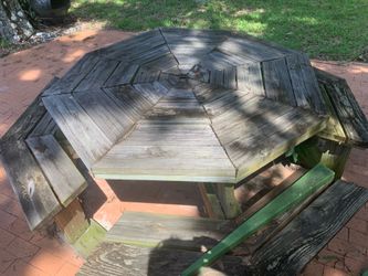 Octagonal wooden picnic table with attached benches.