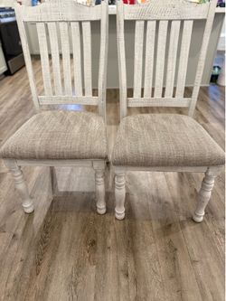 2 distressed white Ashley Furniture dining chairs