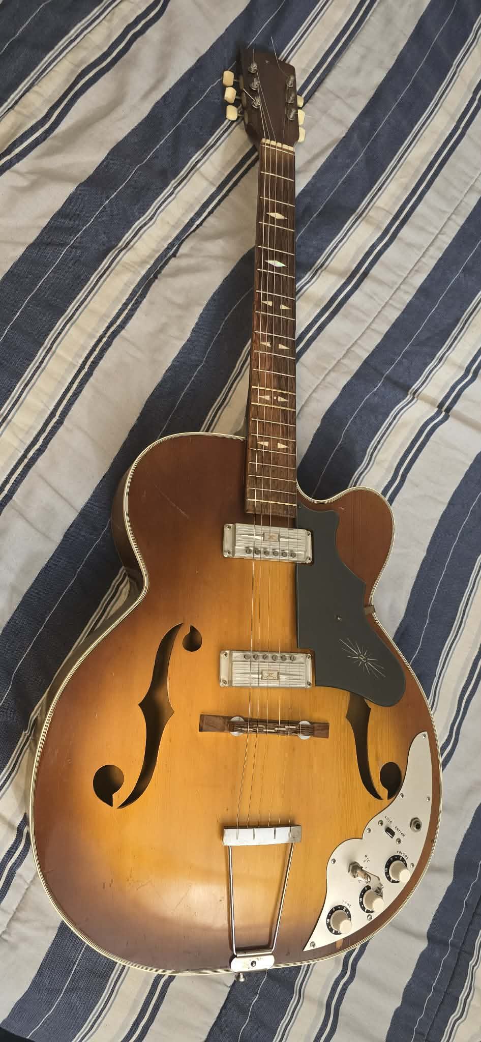 ZEN ON sunburst archtop electric guitar. Guitar has two pickups. F-holes are on body. Control plate with volume, tone, rhythm/solo switch. Trapeze tai