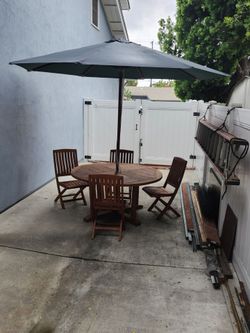 59" teak table, 10' umbrella and 4 teak chairs.
