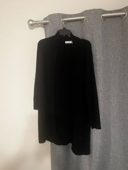 Versatile black longline cardigan from Cloth by Design. This open-front sweater is a size 2X and has two front pockets. The material is a soft knit wi