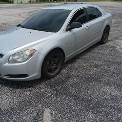 Red Nissan Rogue And Grey Malibu Chevy