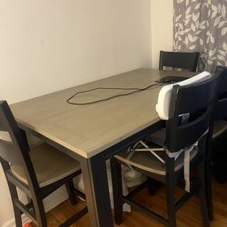 Counter high table set with a middle piece that opens up and makes the table bigger for chairs and a bench that opens the storage