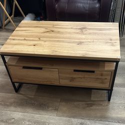 Wooden coffee table with metal frame and two storage drawers with additional storage. In good condition   Dimensions are 40 inches by 24 inches with a