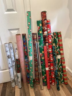 16 rolls of assorted Christmas wrapping paper leftovers