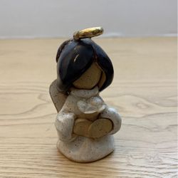 Small clay angel, holding a flower 3” x 2” L2