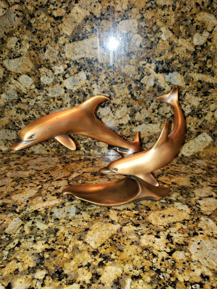 Gold Statue Of Two Dolphins Swimming 