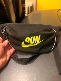 This Nike Run Port Authority waist bag features a vibrant volt green logo printed on the front