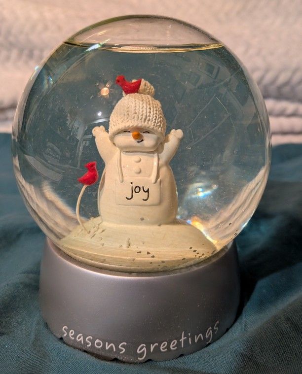 The Snow Globe Features A Snowman With Two Red Cardinal Birds.