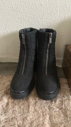 Black quilted ankle boots with chunky platform soles, silver front zippers, and side zip closures