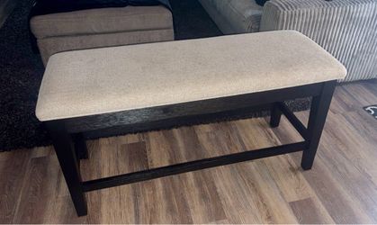 Black bench with beige cushion and storage