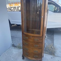 curved-glass  curio cabinet with a multi-drawer base 22” Wide X 12” Deep X 70” High