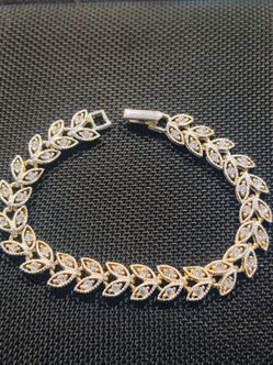 This PORYIMEE tennis bracelet features a wheat ear design plated in silver and embellished with cubic zirconia stones