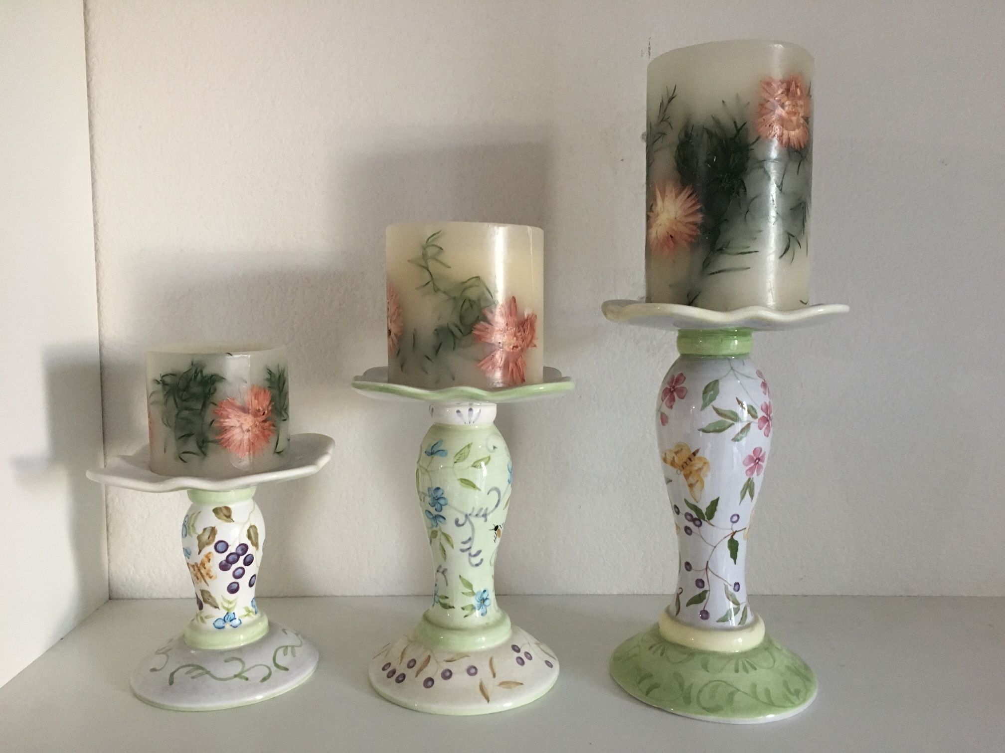 Beautiful candle holders. Hand painted, by Capriware. 5.5” width x 6”, 8” & 10” tall. Beautiful set of 3 pillar candles. 2 are slightly burned, one