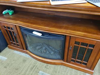 Wooden entertainment center with an integrated electric fireplace insert