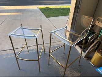 Two CB2 acrylic and gold bar chairs