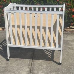 Mini white crib with mattress
