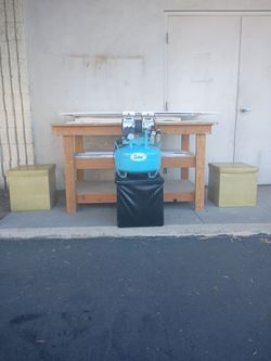 heavy duty. wood work bench with  padded sitting storage containers and potsterboard and frame backing
