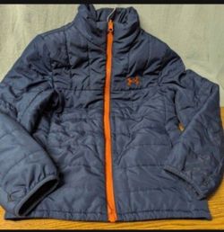 Blue Under Armour zip-up jacket with a attached hood and gray contrast panels on the shoulders and sleeves. Orange UA logo on the chest
Size Small