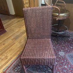 This is a brown wicker dining chair.  