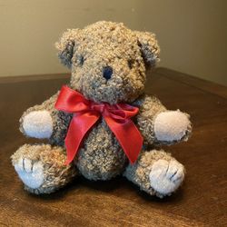 Sitting teddy bear with red bow