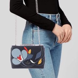 Beautiful Kate Spade New York shoulder bag with a colorful floral appliqué design. Chic, compact, and perfect for everyday wear or special occasions.