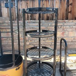 All black round rack with the wheels on the bottom.