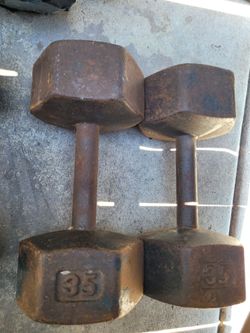 vintage, unbranded 35 lb cast iron hex dumbbells featuring heavy surface rust.
