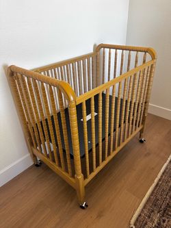 Like New solid wood Mini Crib with removable wheels