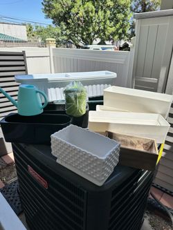 9 plastic containers for plants and 2 watering cans